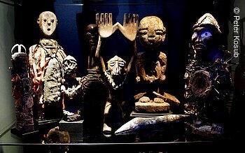 Afrikana Museum (Bad Steben, Frankenwald) Verschiedene traditionelle Holzskulpturen und Figuren in einem Ausstellungsraum.