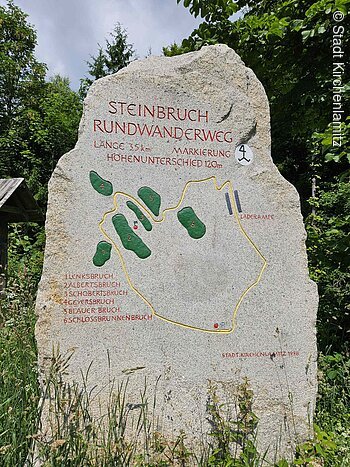Stein mit Karte des Steinbruch-Rundwanderwegs, Länge 3,5 km, Höhenunterschied 120 m, mit markierten Bruchstellen.